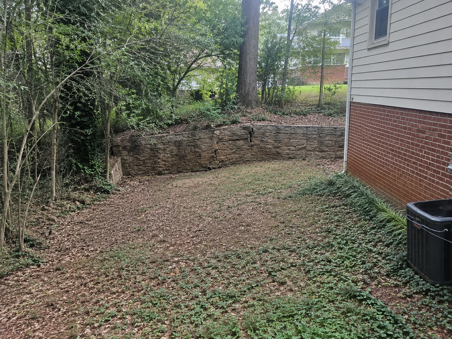 Leaning stone retaining wall on a sloped Adamsville lot in west Atlanta