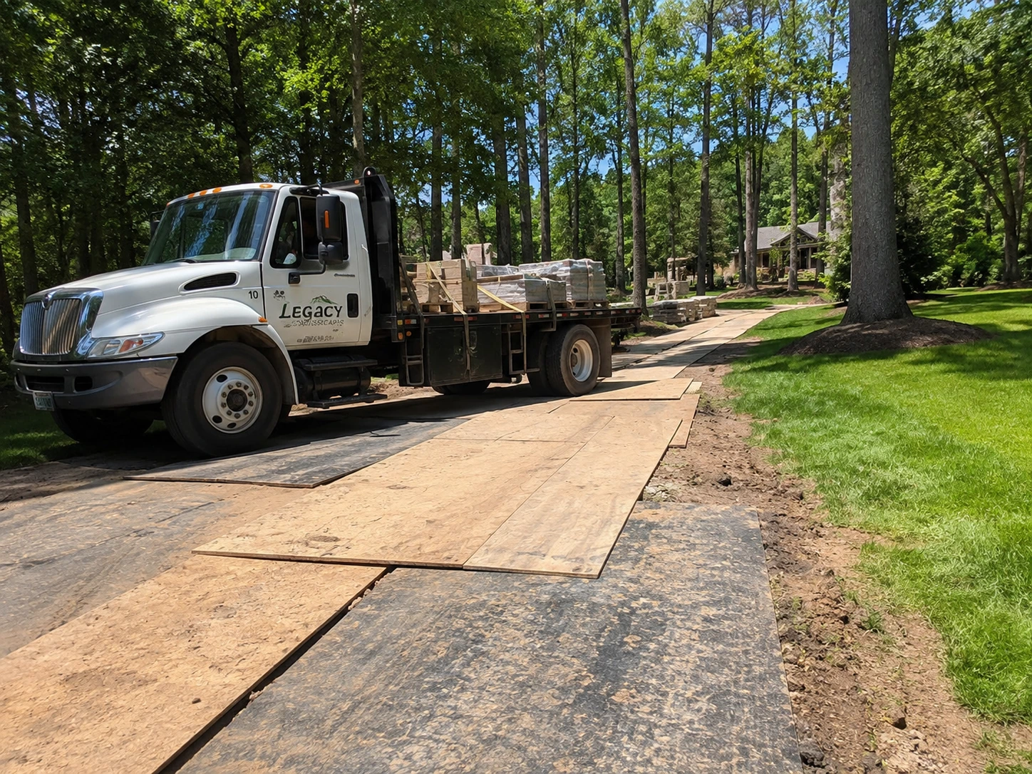 Mats protecting soft ground during a stone delivery on an Enon area lot