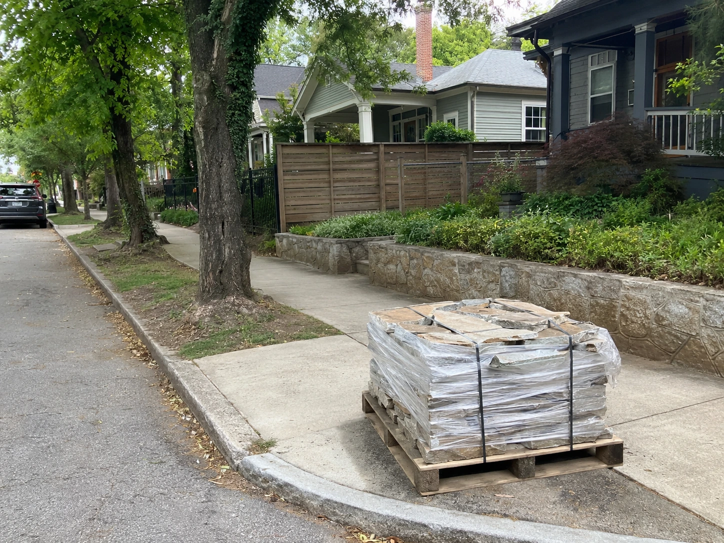 Stone pallet staged on a narrow Virginia-Highland lot with the sidewalk open