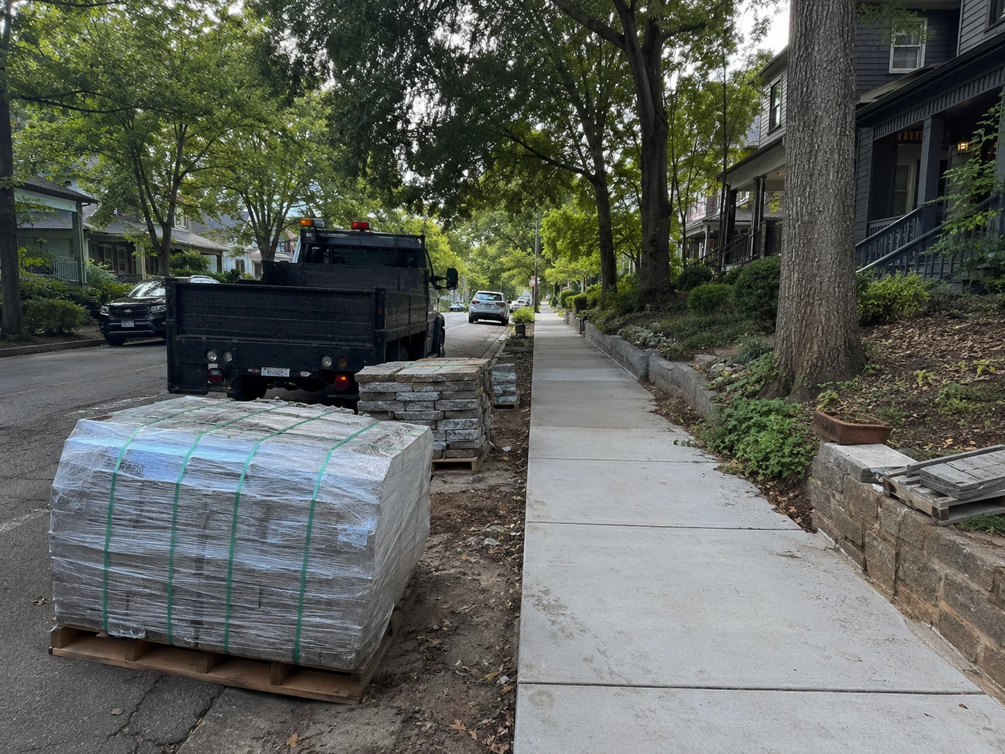 Stone pallet staged on a narrow West End lot with the sidewalk kept clear